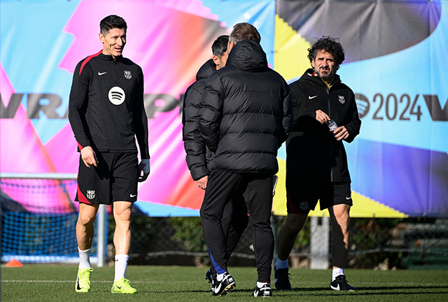 Barcelona's Polish forward #9 Robert Lewandowski speaks with Barcelona's coach Hansi Flick during a training session on the eve of the Spanish league football match between FC Barcelona and Atletico de Madrid at the Joan Gamper training ground in Sant Joan Despi, near Barcelona, on Friday (AFP photo)