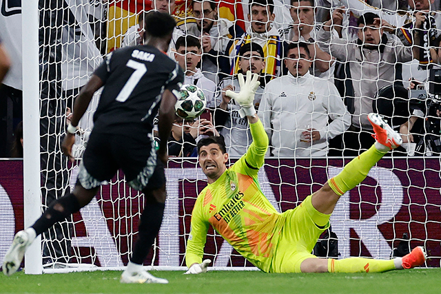 Real Madrid's Belgian goalkeeper #01 Thibaut Courtois stops the ball as Arsenal's English midfielder #07 Bukayo Saka shoots from the penalty spot during the UEFA Champions League quarter final second leg football match between Real Madrid CF and Arsenal at Santiago Bernabeu Stadium in Madrid on Wednesday (AFP photo)