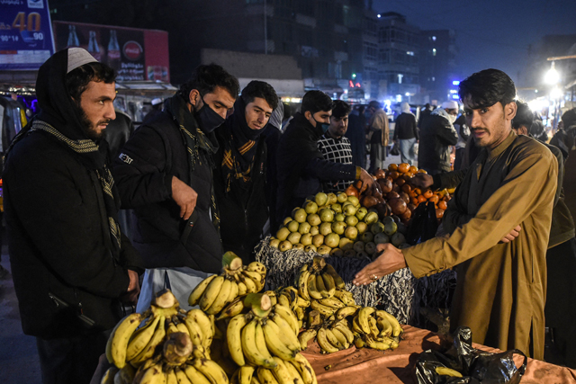 People buy fruits at a roadside stall in a market in Jalalabad, on Sunday (AFP photo)