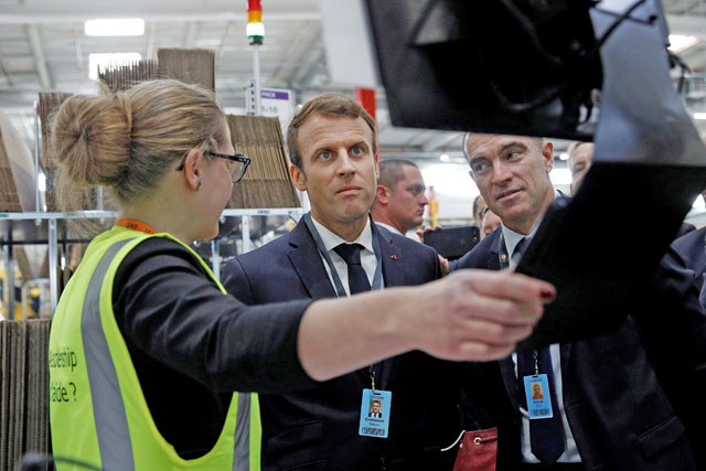 French President Emmanuel Macron (centre) speaks with an employee (left) and Amazon French Operations Director Ronan Bole (right) during a visit at the Amazon factory in Boves, near Amiens, France, on October 3, 2017  (Reuters file photo)