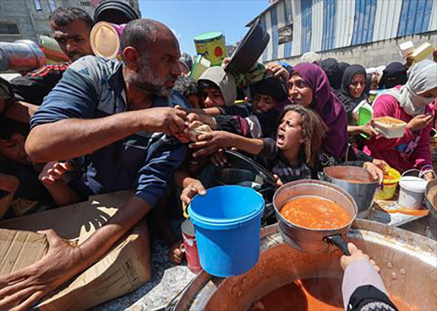 Displaced Palestinians snatch bread loaves distributed by a charity kitchen at the Nuseirat refugee camp in the central Gaza Strip on May 5, 2025 (AFP photo)