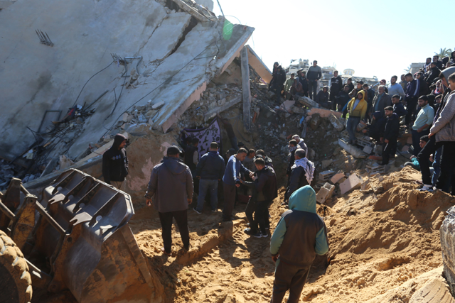Palestinians search through the rubble of a building at the site of an Israeli strike in Khan Yunis in the southern Gaza Strip today (AFP photo)