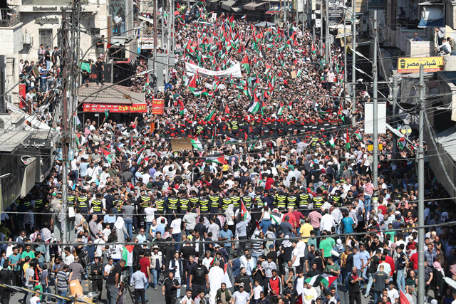Jordanians wave the Palestinian and Jordanian flags during a rally in solidarity with Gaza in Amman on Friday  (AFP photo by Khalil Mazraawi)