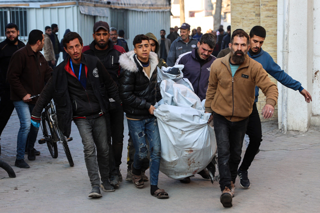 People carry a person injured in an Israeli strike at Al Ahli Arab hospital, also known as the Baptist hospital, in Gaza City on Thursday (AFP photo)