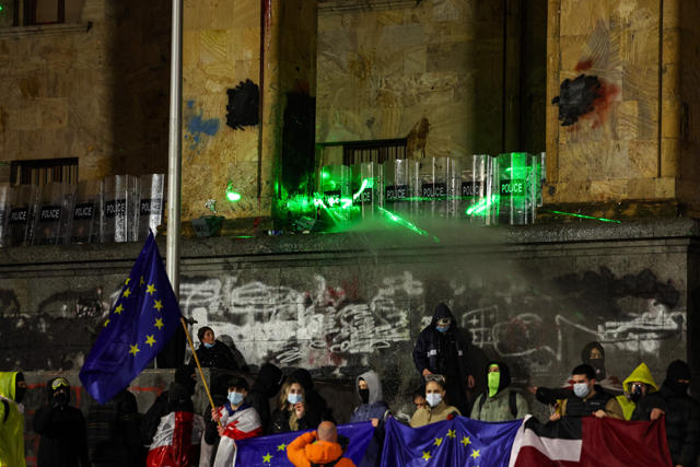 Police form a shield wall and use a water hose while securing the parliament building from protesters during the fifth straight night of demonstrations against the government's postponement of EU accession talks until 2028, in central Tbilisi on Monday (AFP photo)