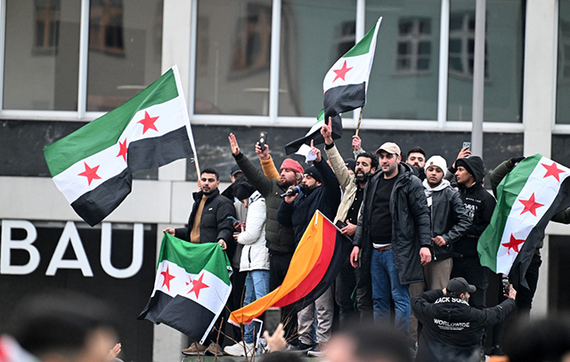 Members of the Syrian community hols flags of Syria and Germany as they rally on December 8, 2024 in Berlin, Germany, to celebrate the end of Syrian dictator Bashar al-Assad's rule after rebels took control of the Syrian capital Damascus overnight  (AFP file photo)