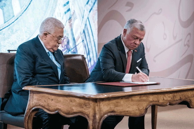His Majesty King Abdullah signs the inauguration of Waqfiyyat Al Mustafa for Khatm Al Koran Al Karim in Al Aqsa Mosque during a ceremony attended by Palestinian President Mahmoud Abbas at Al Husseiniya Palace on Sunday (Photo courtesy of Royal Court)