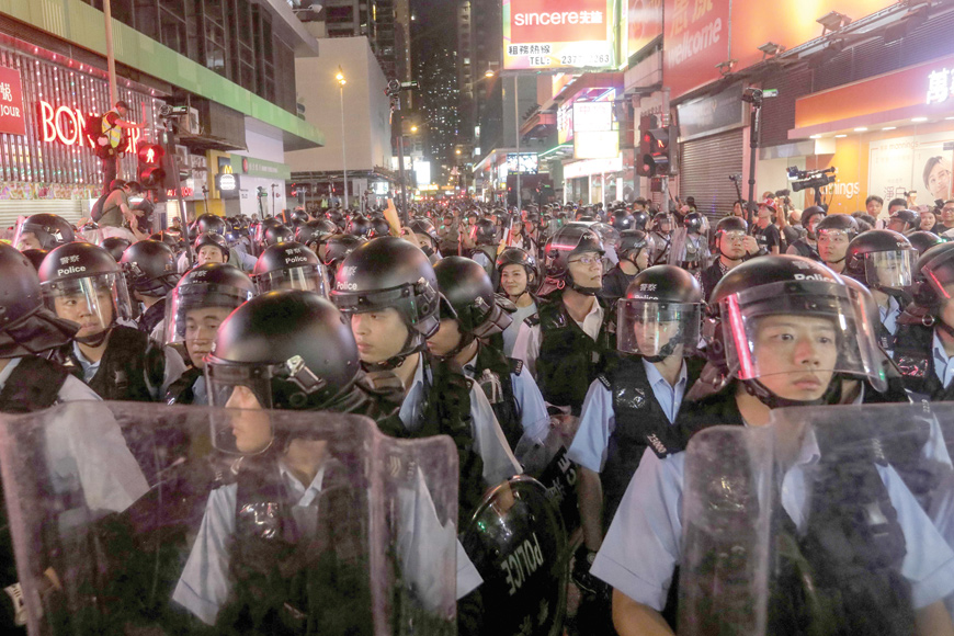 Police gather as they face protesters in the Mong Kok district in Kowloon after taking part in a march to the West Kowloon rail terminus against the proposed extradition bill in Hong Kong, on Sunday (AFP photo)