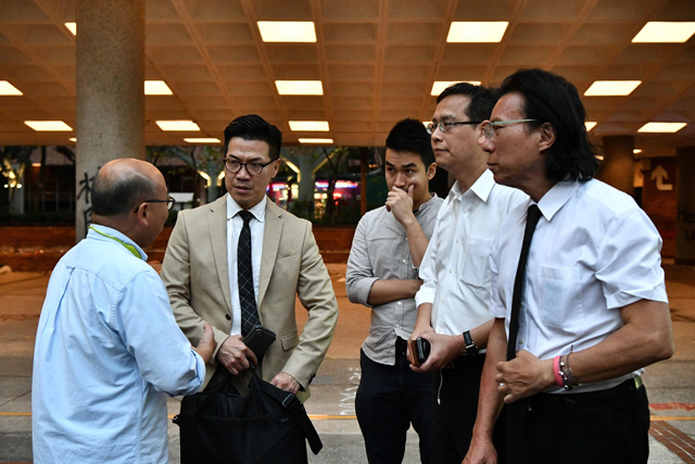 Newly elected district council members, including Gary Fan (2nd left) and Daniel Wong Kwok-tung (right), pay a visit to the Hong Kong Polytechnic University campus where a small number of protesters remain holed up after barricading themselves at the institution over a week ago, in the Hung Hom district in Hong Kong, on Monday (AFP photo)