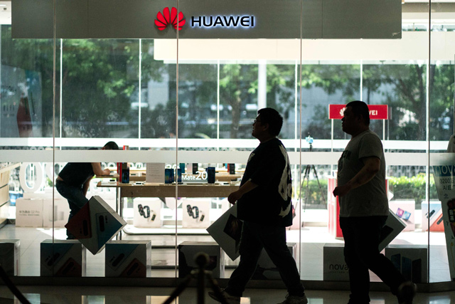 People walk past a Huawei retail store in Beijing, China, on Thursday (AFP photo)