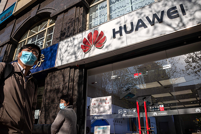 People walk past a Huawei shop in Beijing, on April 22 (AFP photo)
