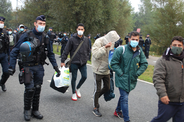 French police evacuate some 800 migrants after they dismantled their camp located near the hospital in Calais, northern France, on Tuesday (AFP photo)