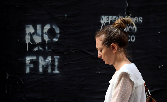 A woman walks past a graffiti that reads ‘No to the IMF’ in Buenos Aires' financial district, Argentina, on October 18  (Reuters file photo)