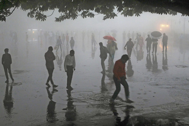 This photo taken on Wednesday shows people walking under heavy rainfall in the northern hill town of Shimla in Himachal Pradesh state (AFP photo)