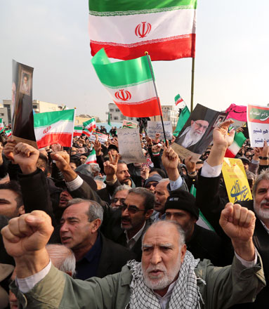 Iranian pro-government demonstrators raise national flags and a picture of the Islamic republic’s supreme leader, Ayatollah Ali Khamenei, during a rally in the capital Tehran’s central Enghelab Square on November 25, 2019, to condemn days of ‘rioting’ that Iran blames on its foreign foes (AFP photo)