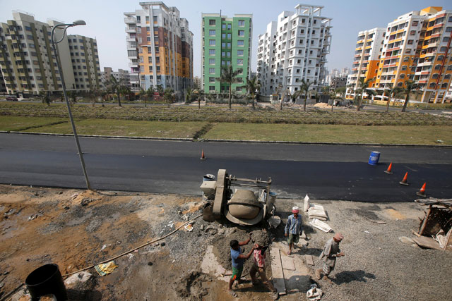 Labourers work at the construction site of a residential complex on the outskirts of Kolkata, India, on Monday  (Reuters photo)