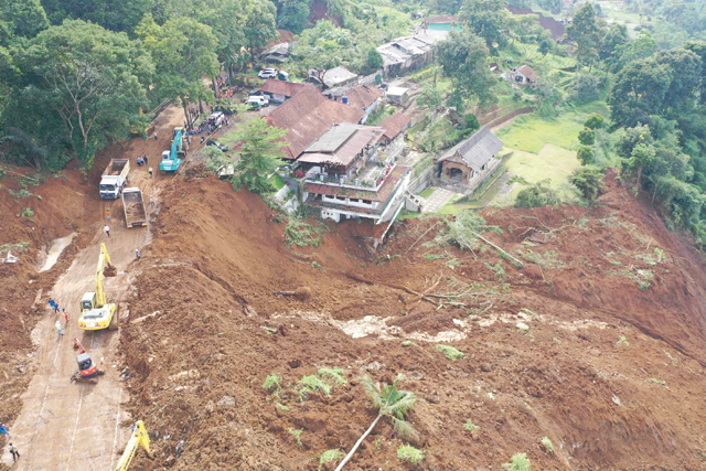 This aerial photo shows workers (left) using heavy equipments to remove soil following landslide triggered by a 5.6-magnitude earthquake near Cianjur on Tuesday (AFP photo)