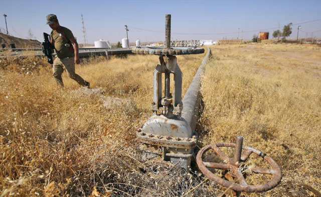 A member of the Iraqi government forces walks next to a pipeline at the Bay Hassan oil field, west of the northern Iraqi city of Kirkuk, on October 19 (AFP file  photo)