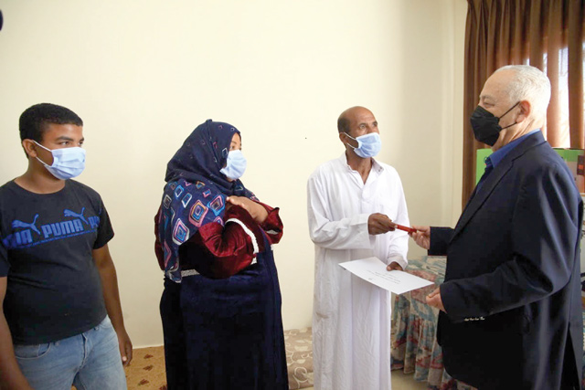 Royal Court Chief Yousef Issawi hands over keys of a new house, built as part of a Royal initiative, to a beneficiary family on Saturday (Petra photo)