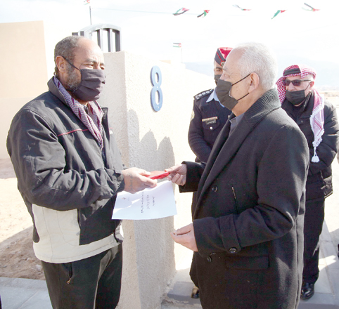 Royal Court Chief Yousef Issawi hands over keys to a new house, built as part of a Royal initiative, to a beneficiary on Saturday (Petra photo)