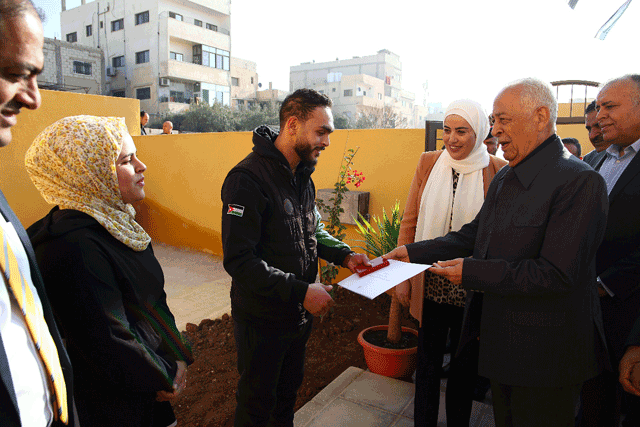 Royal Court Chief Yousef Issawi hands over keys to a new house, built as part of a Royal initiative, to a beneficiary in Russeifa on Saturday (Petra photo)