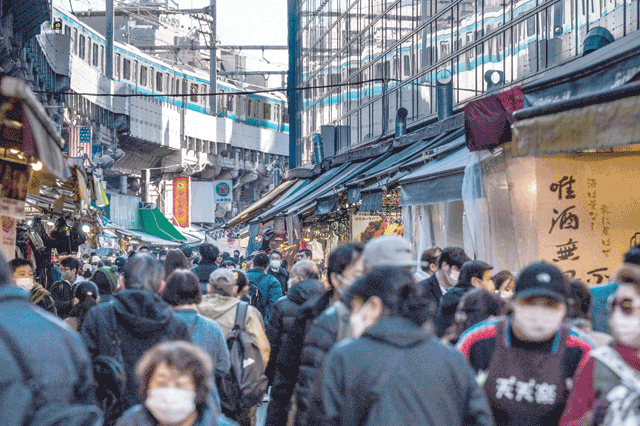 People walk past shops in the popular shopping area of Ueno in Tokyo on Friday (AFP photo)