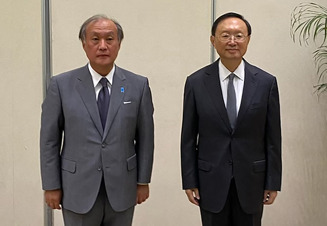 This handout photo taken on Wednesday released by the National Security Agency of Japan on Thursday shows Takeo Akiba (left), secretary general of Japan's National Security Secretariat, and China's foreign policy chief Yang Jiechi posing for photographs in Tianjin (AFP photo)