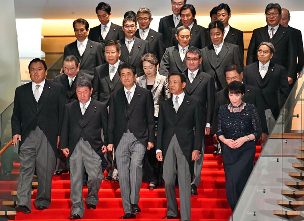 Japan’s Prime Minister Shinzo Abe (front centre) walks down the stairs with his new Cabinet at his official residence in Tokyo following a Cabinet reshuffle earlier in the day on Wednesday (AFP photo)