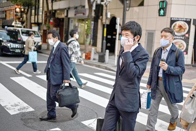 People walk on a pedestrian crossing in Tokyo Monday, as government data showed Japan's economy exited recession in Q3 (AFP photo)