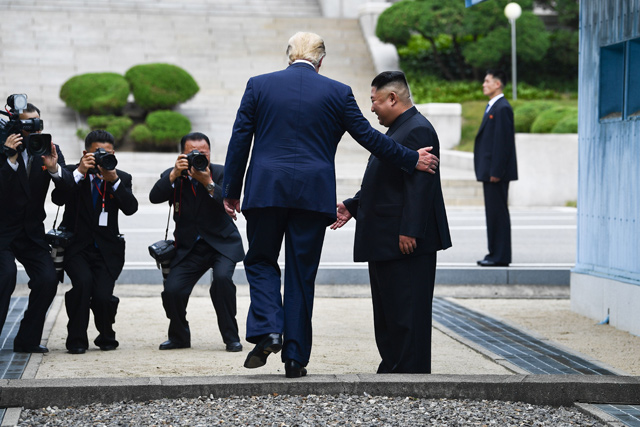 US President Donald Trump steps into the northern side of the Military Demarcation Line that divides North and South Korea, as North Korea's leader Kim Jong-un looks on, in the Joint Security Area of Panmunjom in the Demilitarised zone, on Sunday (AFP photo)