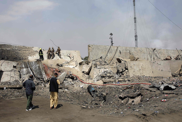 Afghan security forces investigate at the site near the crater from where a tractor packed with explosives exploded the night before at the Green Village in Kabul on Tuesday (AFP photo)