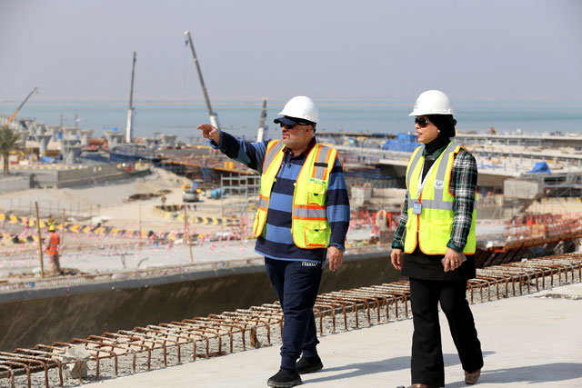 Ahmad Al Hassan (left), assistant undersecretary for road engineering at the public works ministry and project engineer Mai Al Messad walk at the construction site of the Jaber Causeway in Kuwait City on February 11 (AFP photo)