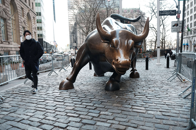 A man walks by the Wall Street Bull by the New York Stock Exchange on Tuesday in New York City (AFP photo)