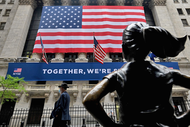 A man passes the building before the opening bell at the New York Stock Exchange on May 26, on Wall Street in New York City  (AFP photo)