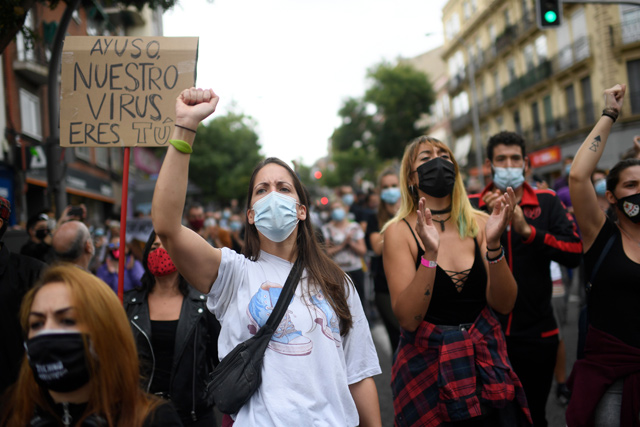 People attend a demonstration at the Vallecas neighbourhood in Madrid, on Sunday to protest against the new restrictive measures announced by regional authorities (AFP photo)