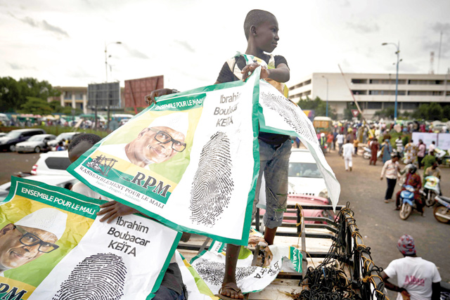 A Malian child standing on the top of a van holds electoral posters of Mali's incumbent President Ibrahim Boubacar Keita during his last political rally in Bamako on Friday ahead of the runoff vote in Mali's presidential election on August 12 (AFP photo)