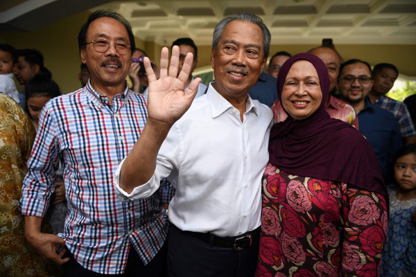 Malaysia’s former interior minister Muhyiddin Yassin (centre), his wife Noraini Abdul Rahman talk to the press outside his home in Kuala Lumpur, on Saturday   (AFP photo)