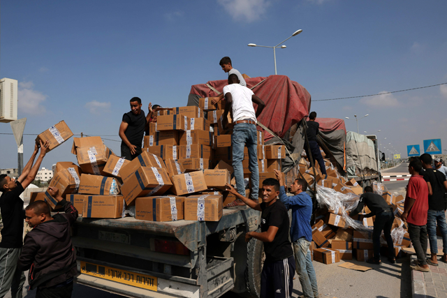 People unpack boxes of humanitarian aid from a truck that entered the southern Gaza Strip from Egypt via the Rafah border crossing on November 2, 2023 (AFP photo)