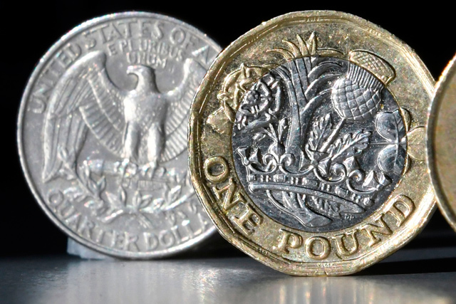 A British one pound sterling coin and a US quarter dollar coin are arranged and photographed in central London, on October 5, 2017 (AFP file photo)