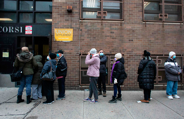 People wait in line for Pfizer COVID-19 vaccines at the opening of a new vaccination site at Corsi Houses in Harlem New York, on Friday (AFP photo)