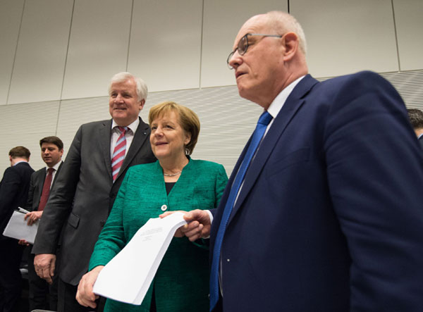 Horst Seehofer (left), leader of the conservative Christian Social Union Party (CSU), German chancellor and leader of the conservative Christian Democratic Union Party, Angela Merkel (centre) and parliamentary group leader of the conservative CDU/CSU Party faction, Volker Kauder (right) show a copy of the coalition agreement before a parliamentary group meeting in Berlin on Wednesday, after conservatives and the Social Democrats sealed a deal on a new coalition (AFP photo)