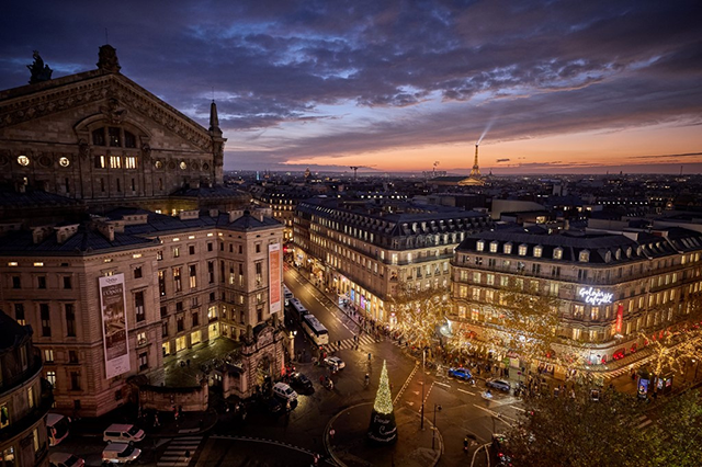Christmas lights are pictured at the Galeries Lafayette department store in Paris with the Eiffel Tower seen in the background at sunset on Nov. 25, 2024  (AFP file photo) 