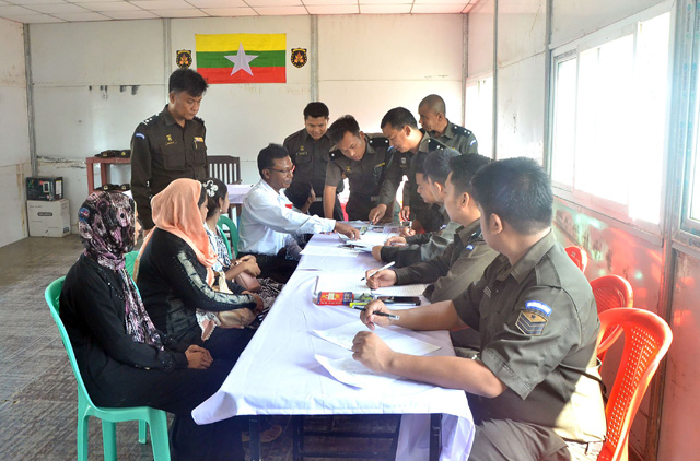 In this handout photo released by Myanmar News Agency on Sunday and taken on Saturday, a Myanmar immigration official hands over identification document to an unidentified Rohingya woman belonging to the five-member Rohingya family at Taungpyoletwei town repatriation camp in Maungdaw near Bangladesh border (AFP photo)