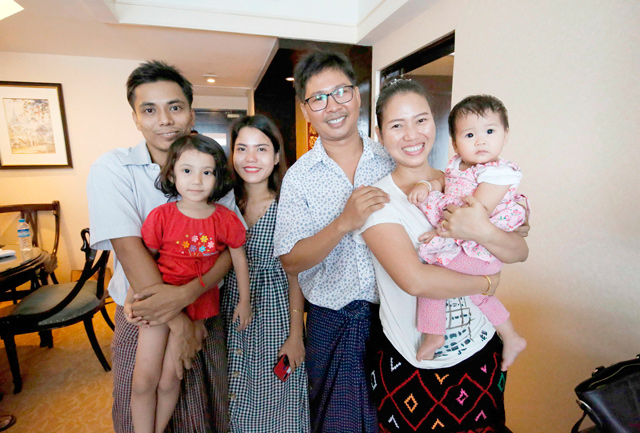 Reuters journalist Wa Lone (3rd right) poses with his wife Pan Ei Mon (2nd right) and daughter along with his colleague Kyaw Soe Oo (left) carrying his daughter and his wife Chit Su Win after being freed from prison in a presidential amnesty in Yangon, on Tuesday (AFP photo)