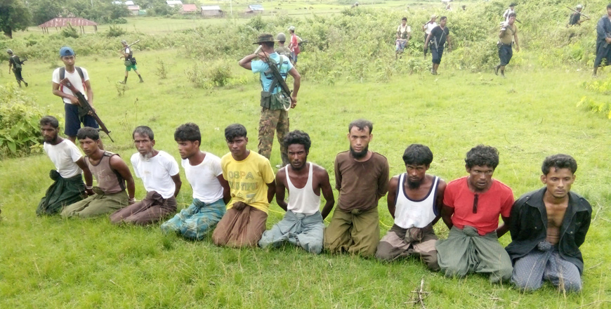 Ten Rohingya men with their hands bound kneel as members of the Myanmar security forces stand guard, in Inn Din village, on September 2, 2017 (Reuters photo)
