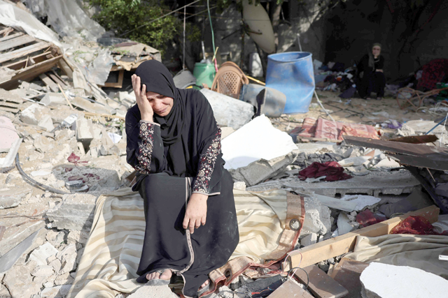 A woman sits amidst the rubble of her house at Nusseirat refugee camp in Gaza, on Sunday, amid a ceasefire ending five days of deadly fighting between Israel and the Palestinian Islamic Jihad group (AFP photo)