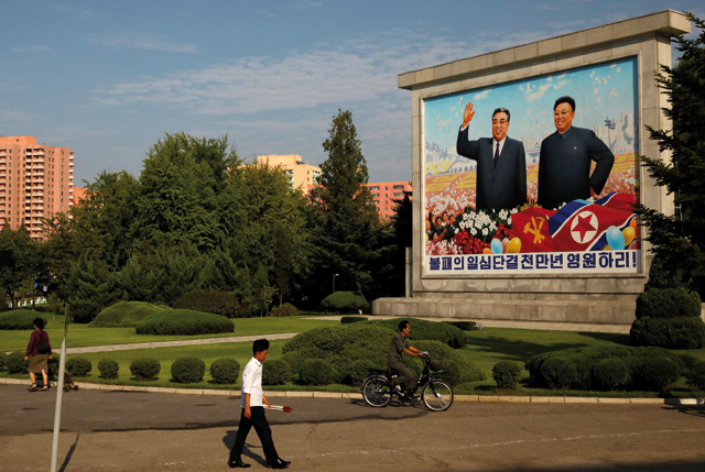  Residents pass by a painting featuring late North Korean leaders Kim Il-sung (left ) and Kim Jong-il ahead of 70th anniversary of North Korea's foundation in Pyongyang on Thursday (Reuters photo)