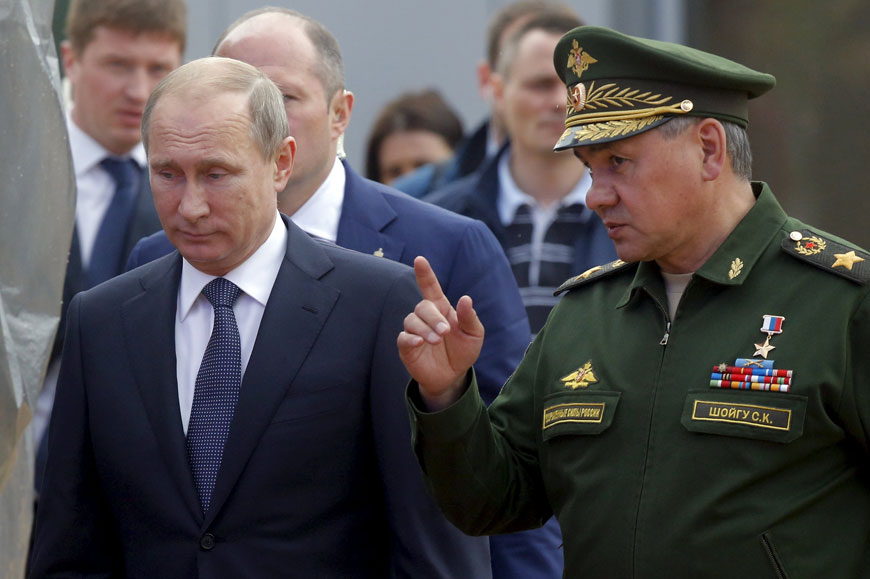 Russian President Vladimir Putin listens to Defence Minister Sergei Shoigu as they arrive for the opening of the Army-2015 international military forum in Kubinka, outside Moscow, Russia, on Tuesday (Reuters photo)