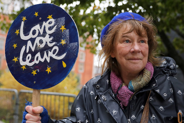 An anti-Brexit activist holds a placard as she demonstrates outside of the houses of parliament in central London on Monday (AFP photo)