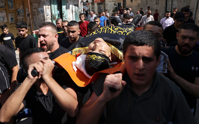 Palestinian men carry the body of Dhurar Al Kafrini, reportedly killed during confrontations with Israeli forces in the Jenin refugee camp, during his funeral in the occupied West Bank on Tuesday (AFP photo)